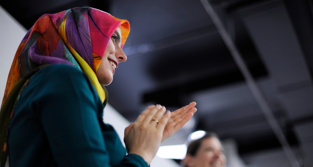 Woman stood giving applause at business meeting