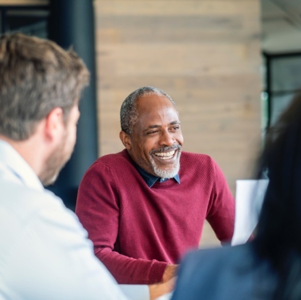 New employee smiling during meeting with colleagues