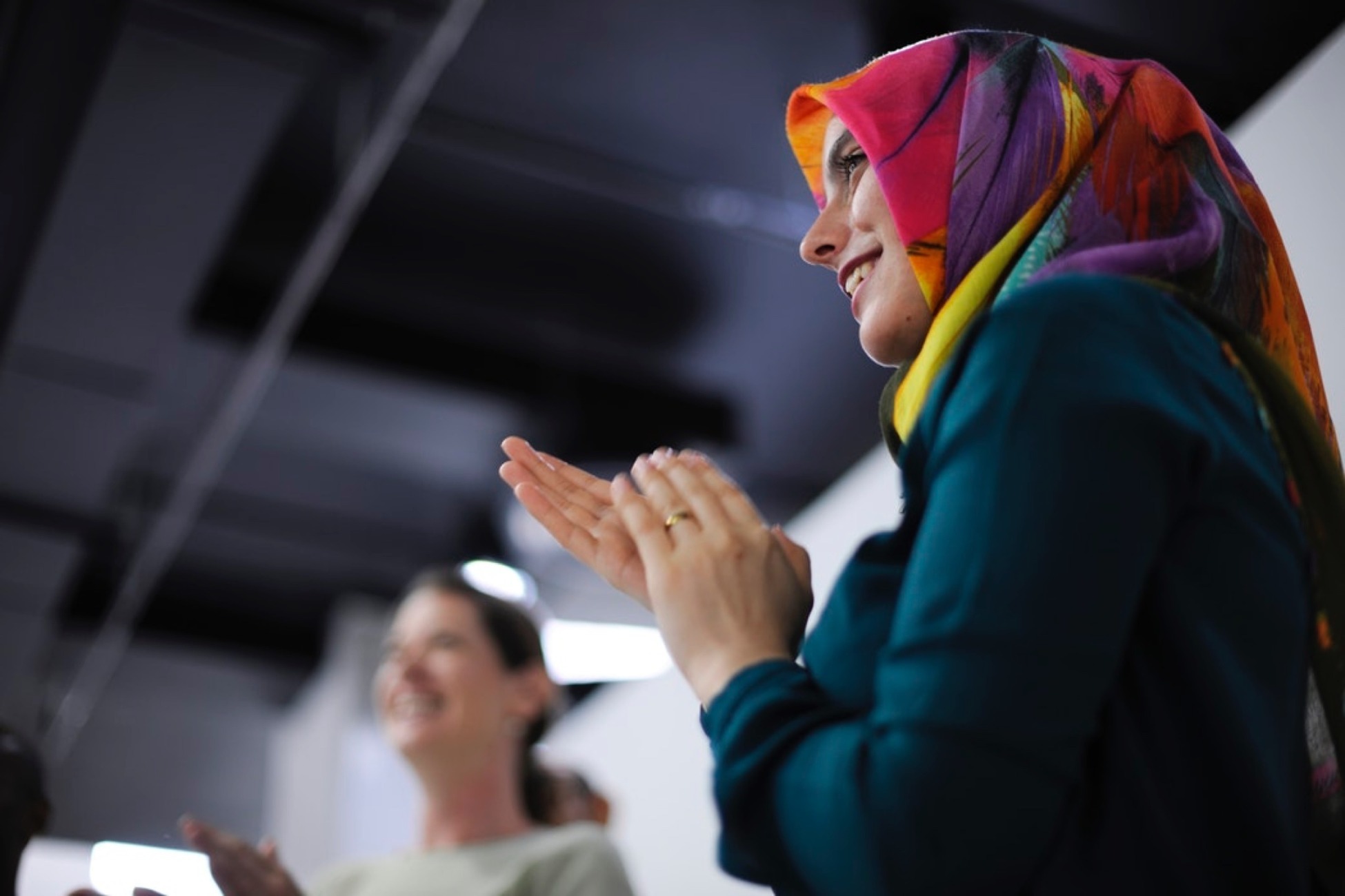 Woman stood giving applause at business meeting